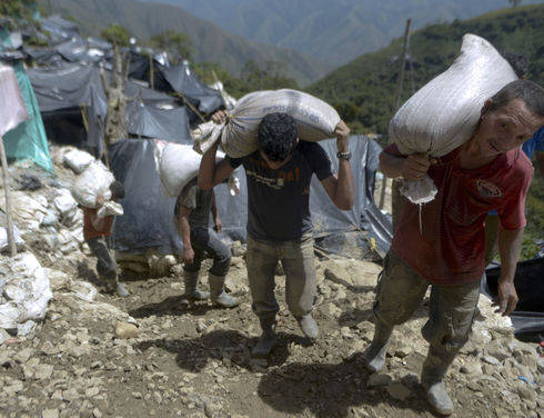 Miners carry sacks of gold extracted from an illegal mine in the village of San Antonio in the department of Antioquia. (Raúl Arboleda/AFP)